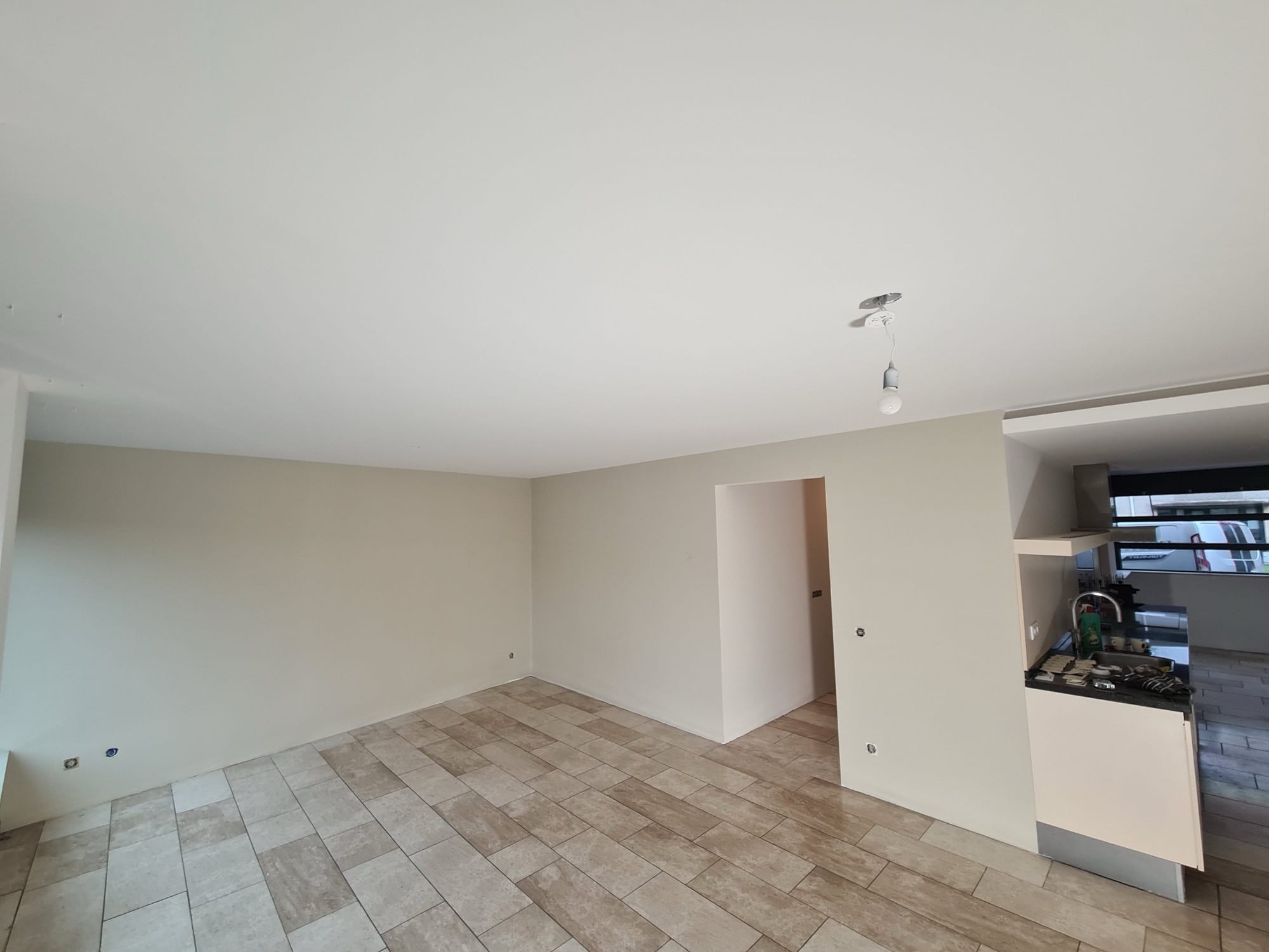 Strak gestuukte woonkamer met open keuken, klaar voor de verf