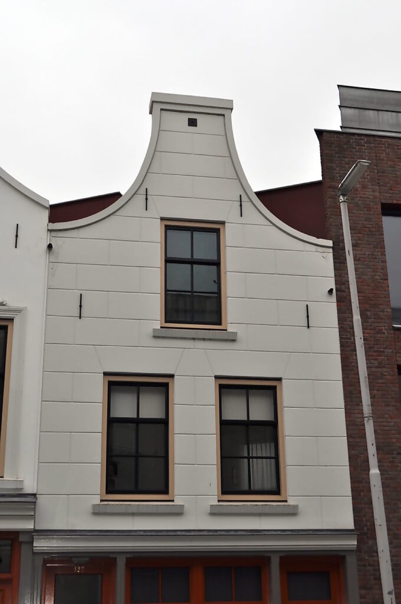 Strak gepleisterde klokgevel met een nette vakverdeling in het pleisterwerk