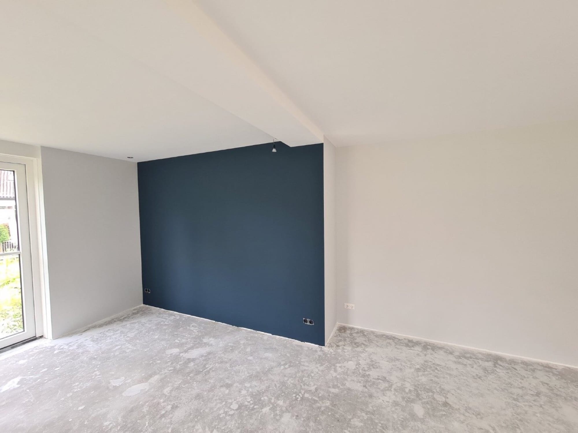 Petrolblauwe accentwand in een vers gesauste kamer