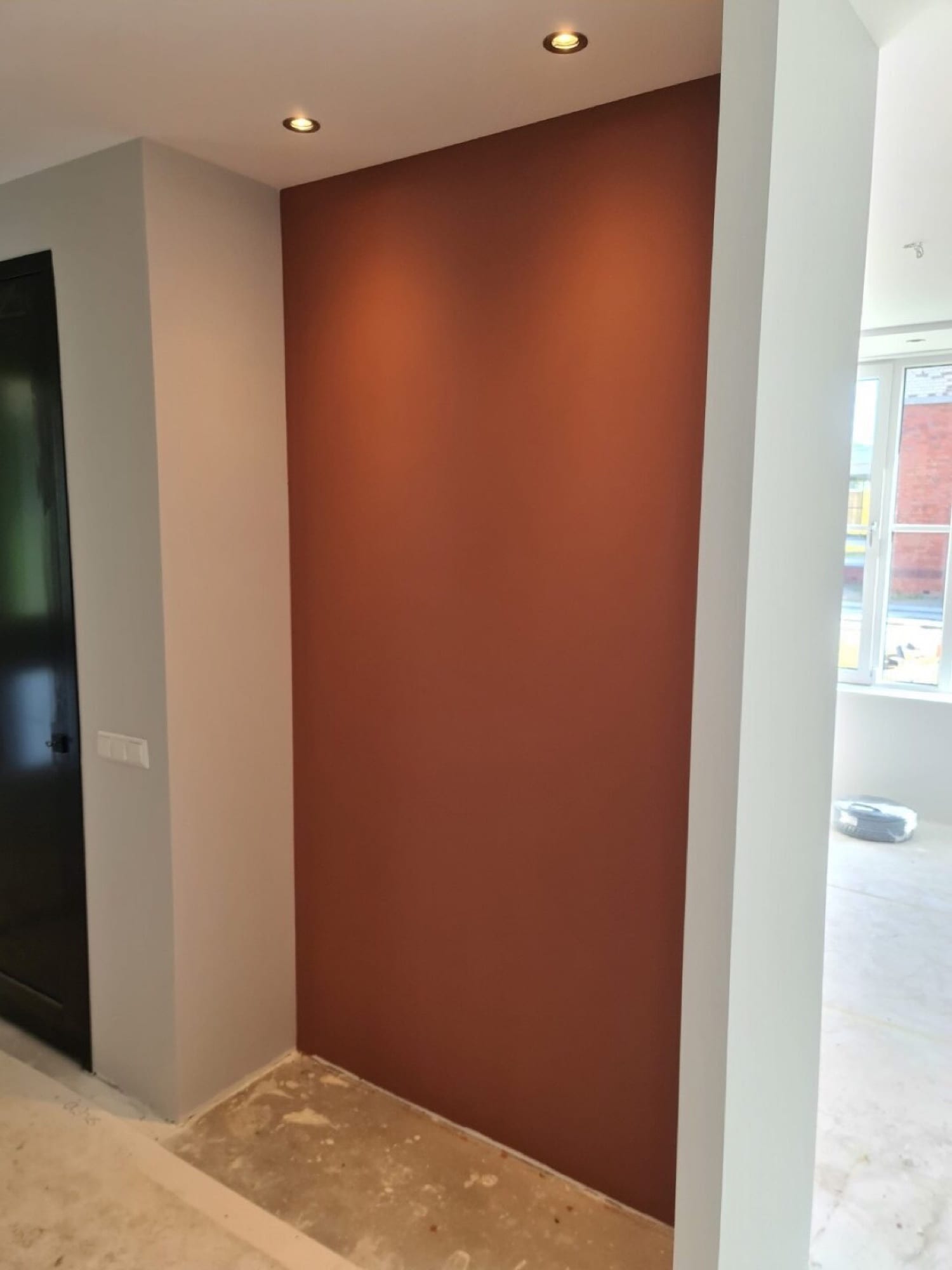 Glad gestuukte accentwand in terracotta met inbouwspots