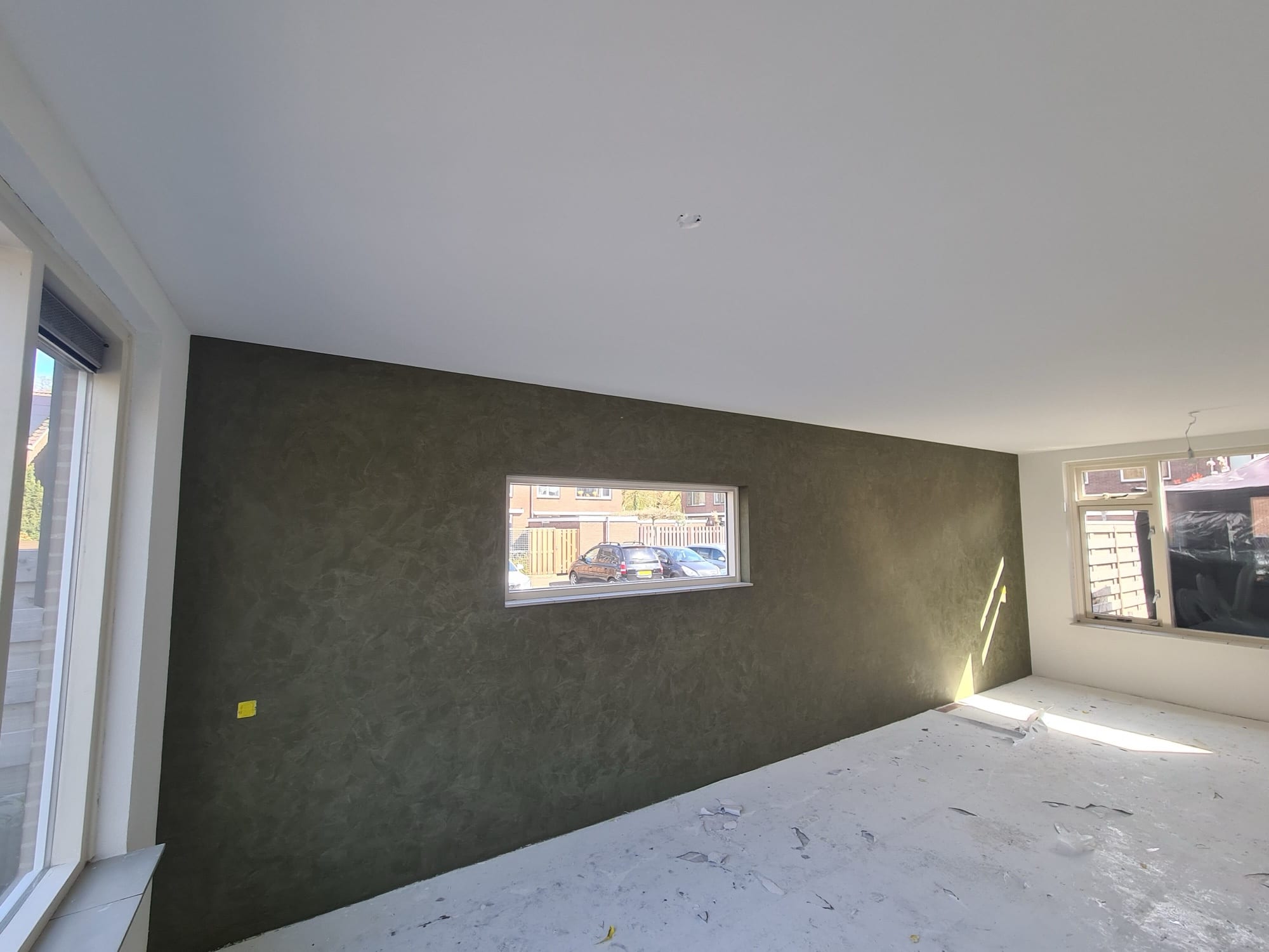 Donkergroene stucco wand, strak en mat opgeleverd