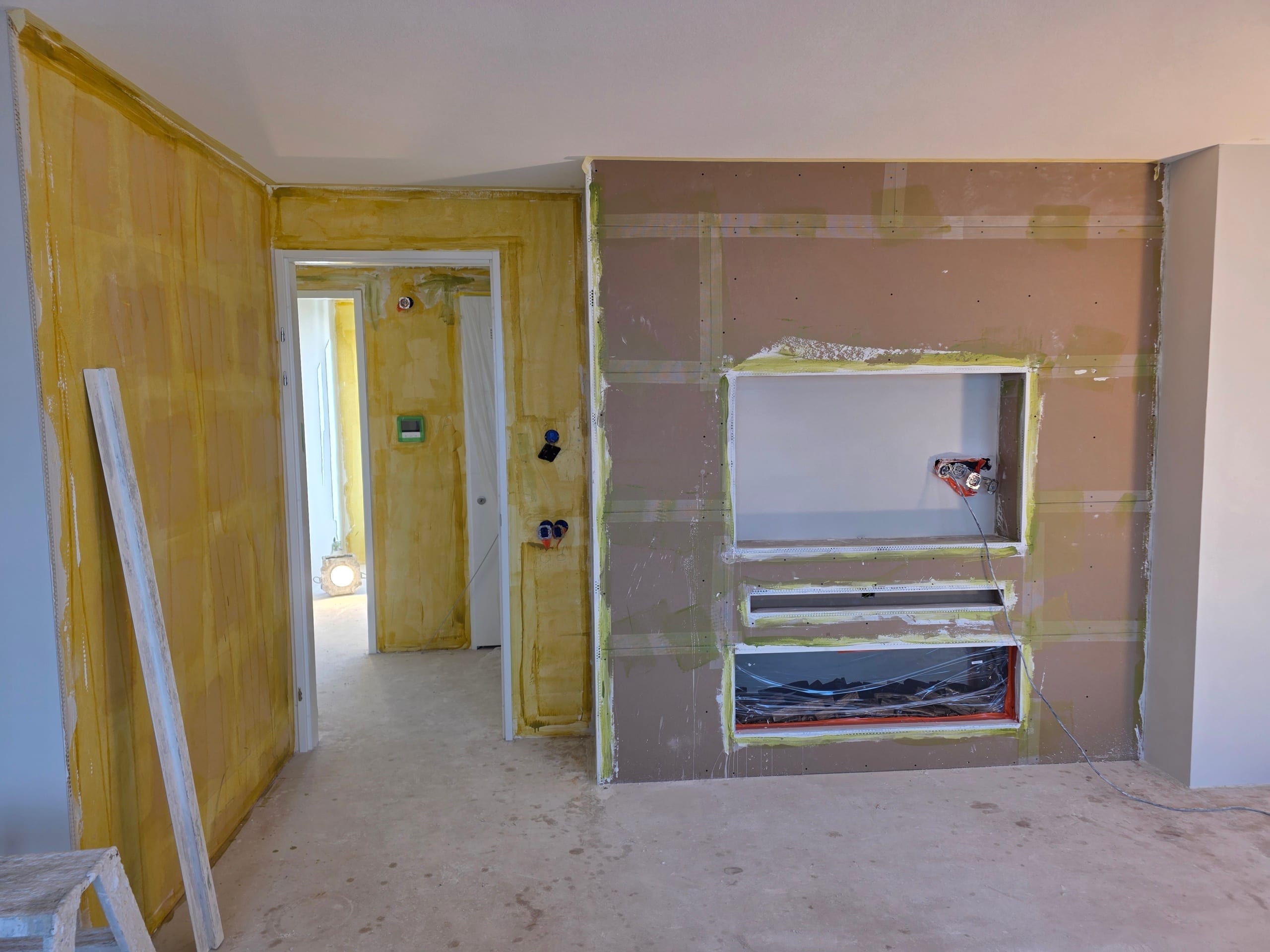 Cinewall in ruwe gipsplaat met tv-nis en haardopening, voor het stucwerk