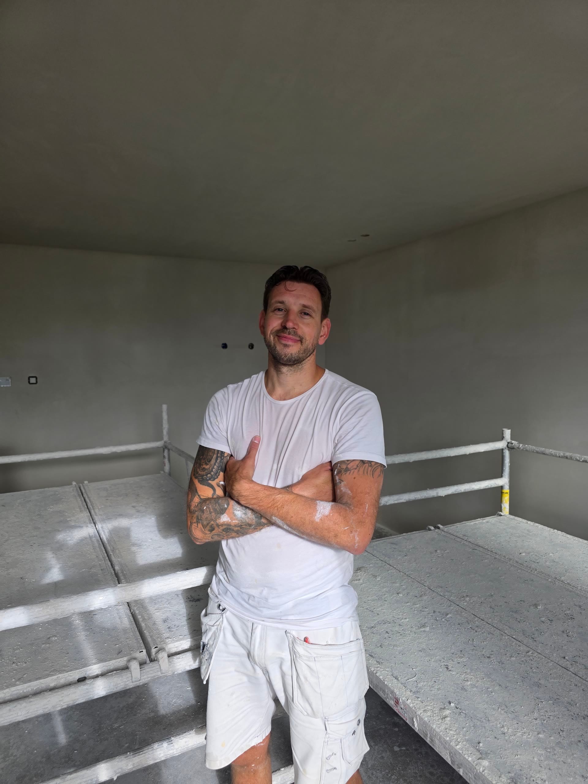 Pascal op de steiger voor een pas opgezette wand, met het plafond al glad