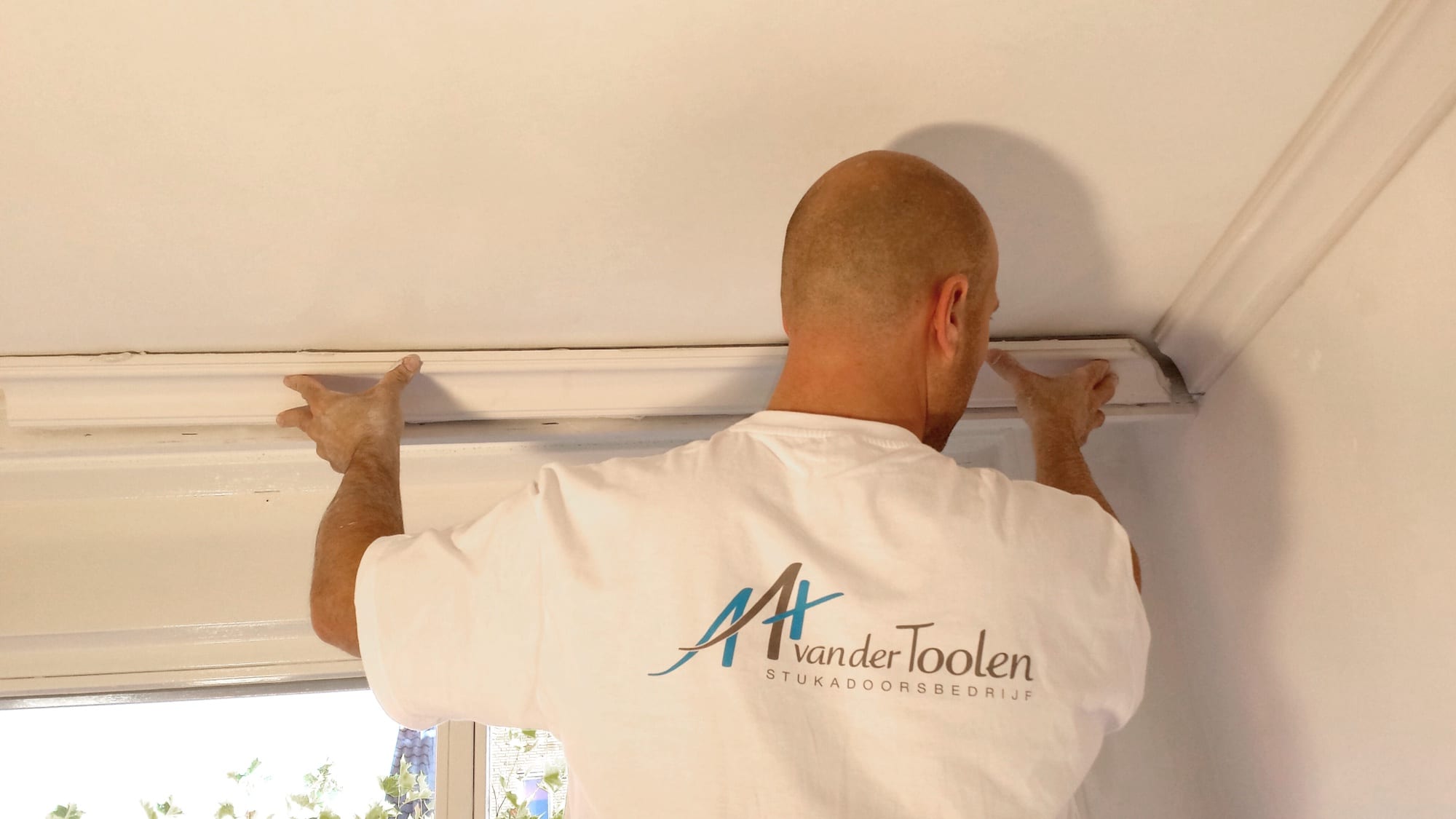 Stukadoor brengt een kooflijst aan langs het plafond
