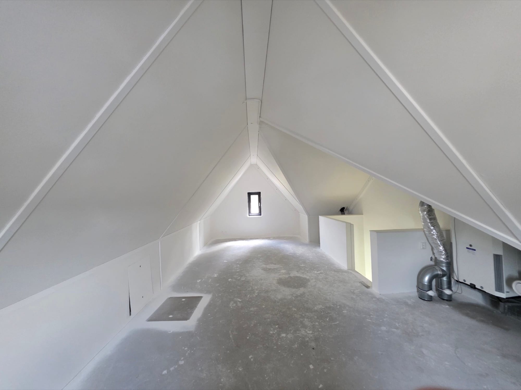 Symmetrisch beeld van de strak afgewerkte zolder met wit gespoten kapconstructie