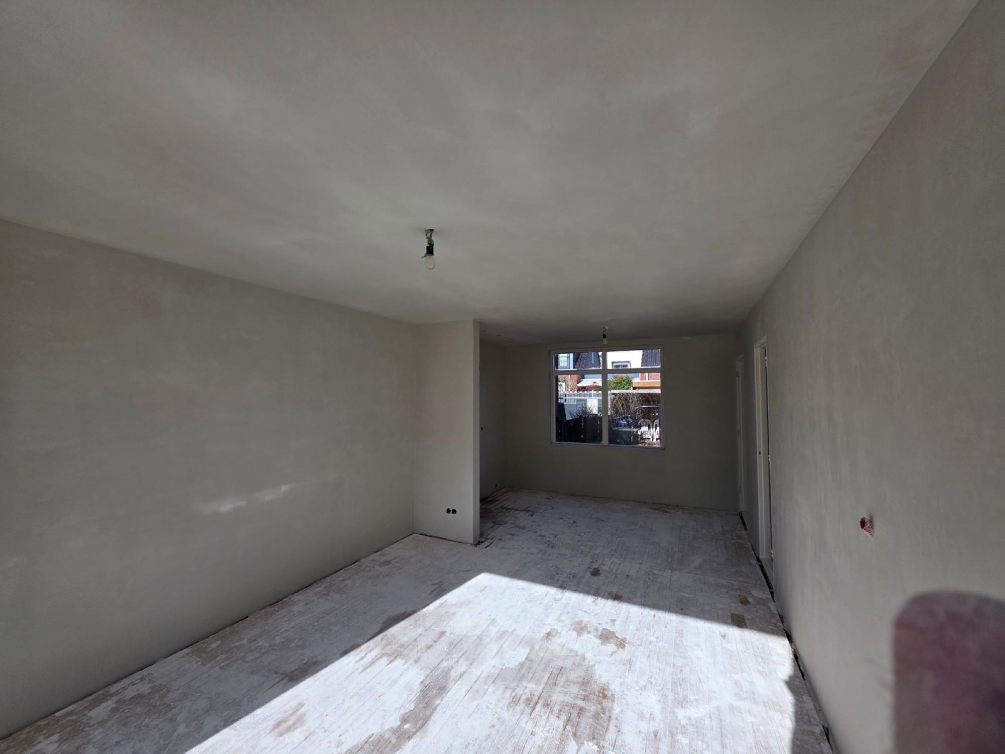 Woonkamer sausklaar gestuukt na de renovatie, wanden en plafond strak