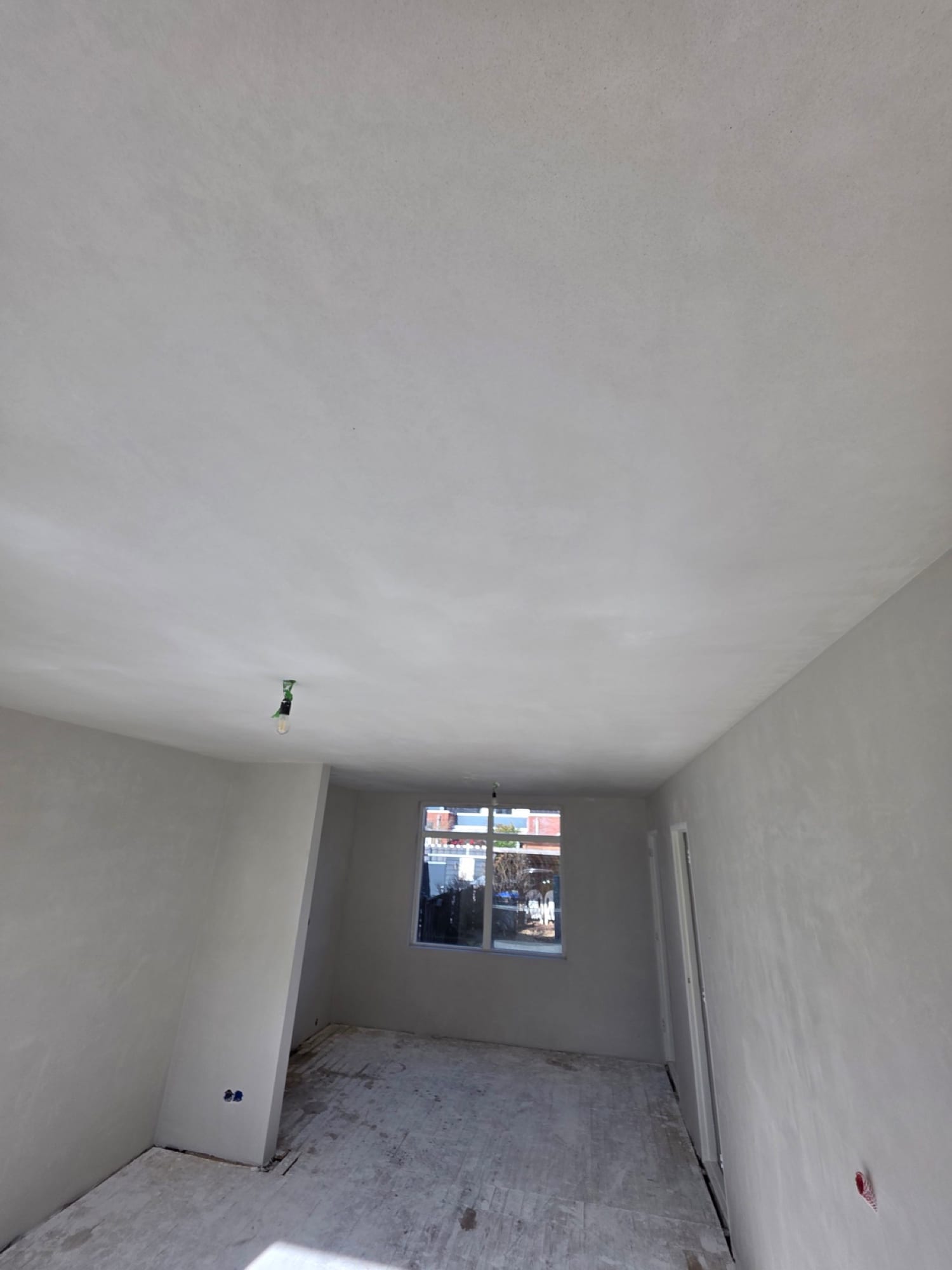 Strak gestuukt plafond en wanden in de woonkamer, klaar voor de saus