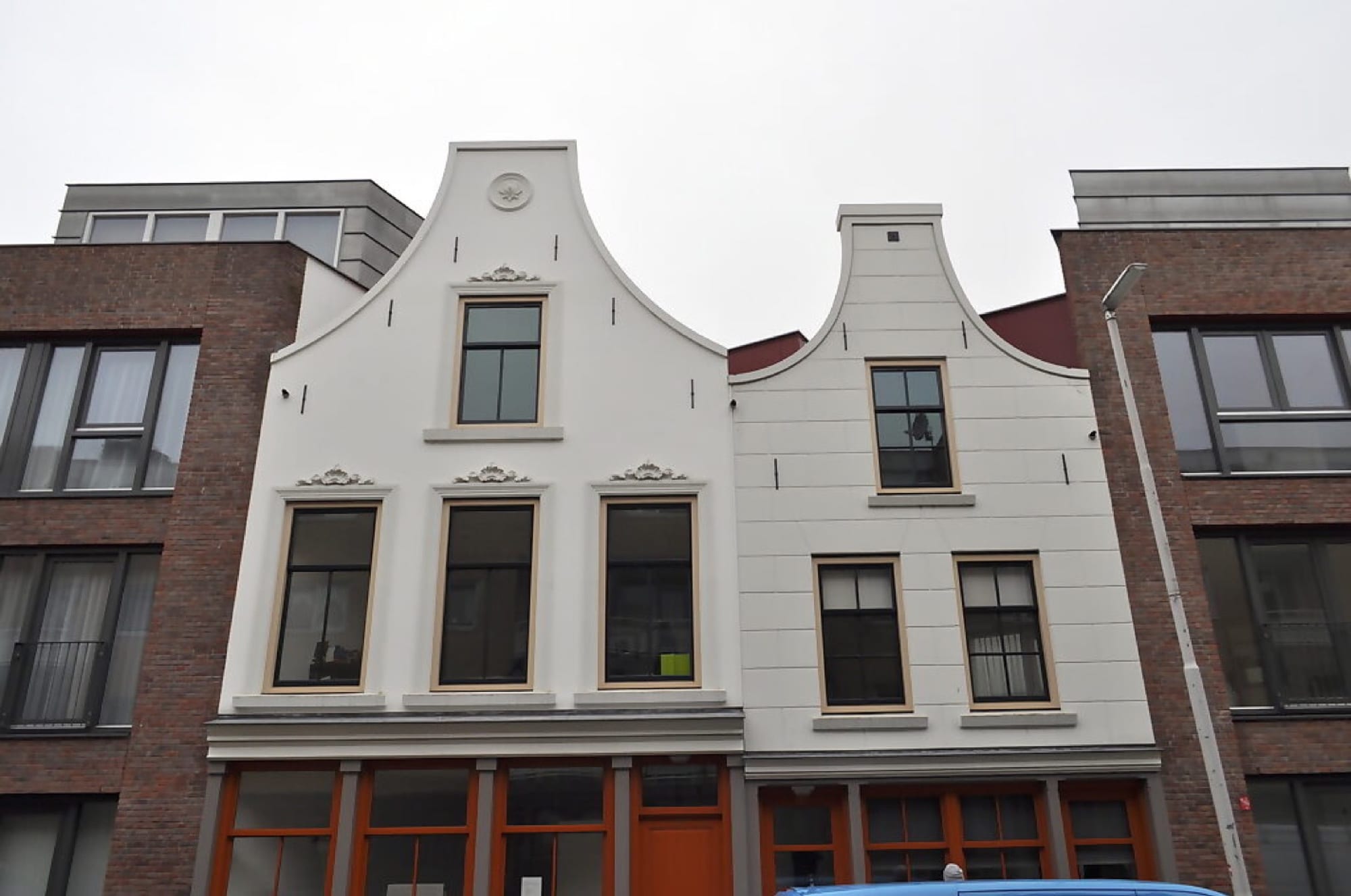 Twee volledig gerestaureerde klokgevels naast elkaar, opnieuw gepleisterd