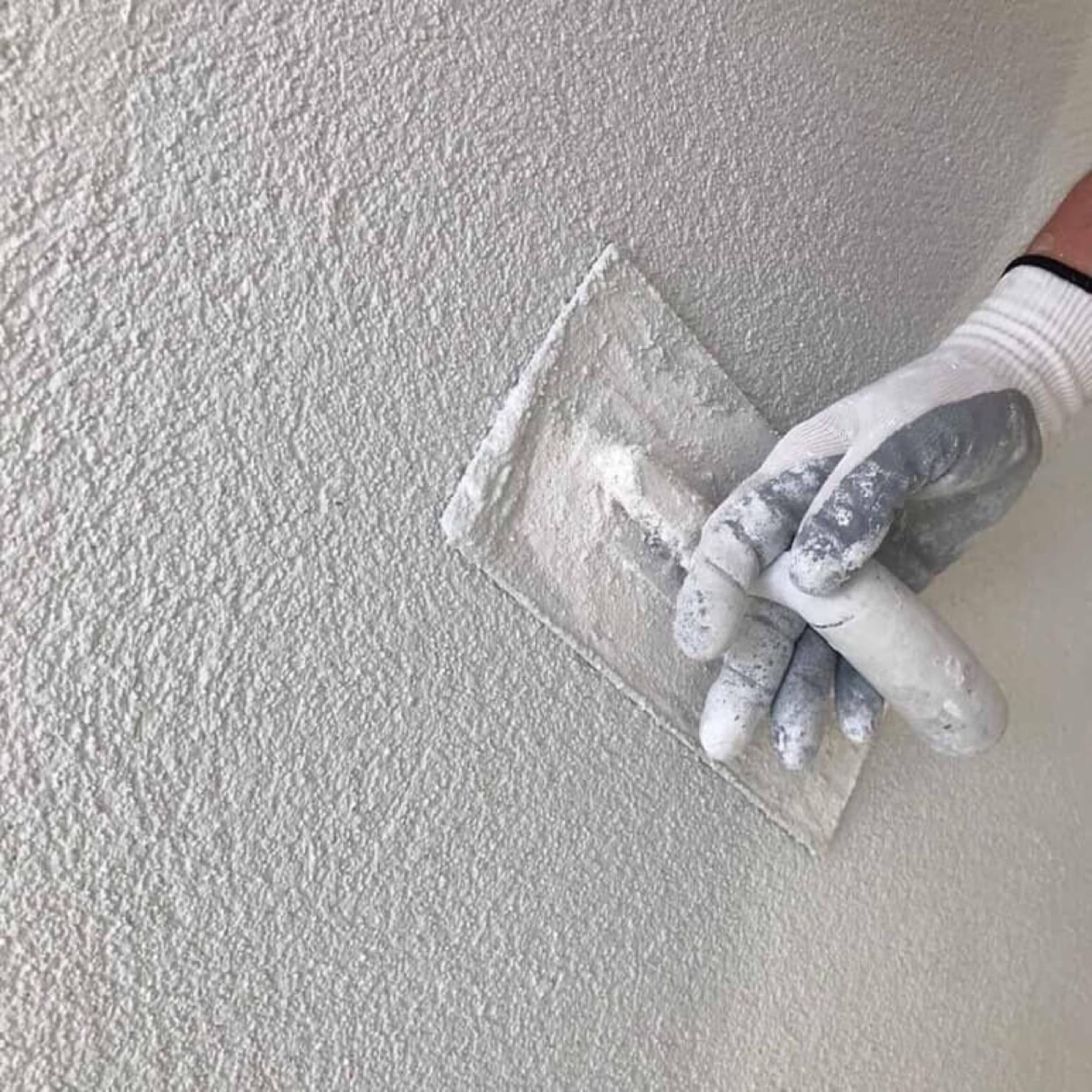 Close-up van spachtelputz sierpleister die met de spaan wordt aangebracht